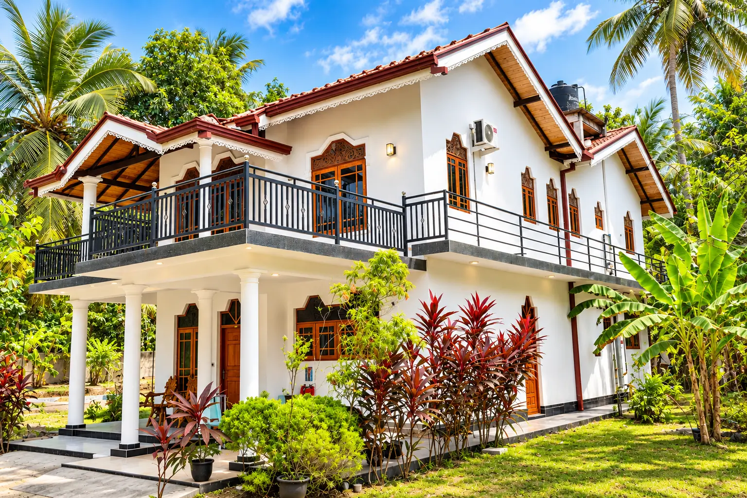 Front of Natarich villa with a first-floor balcony and palms